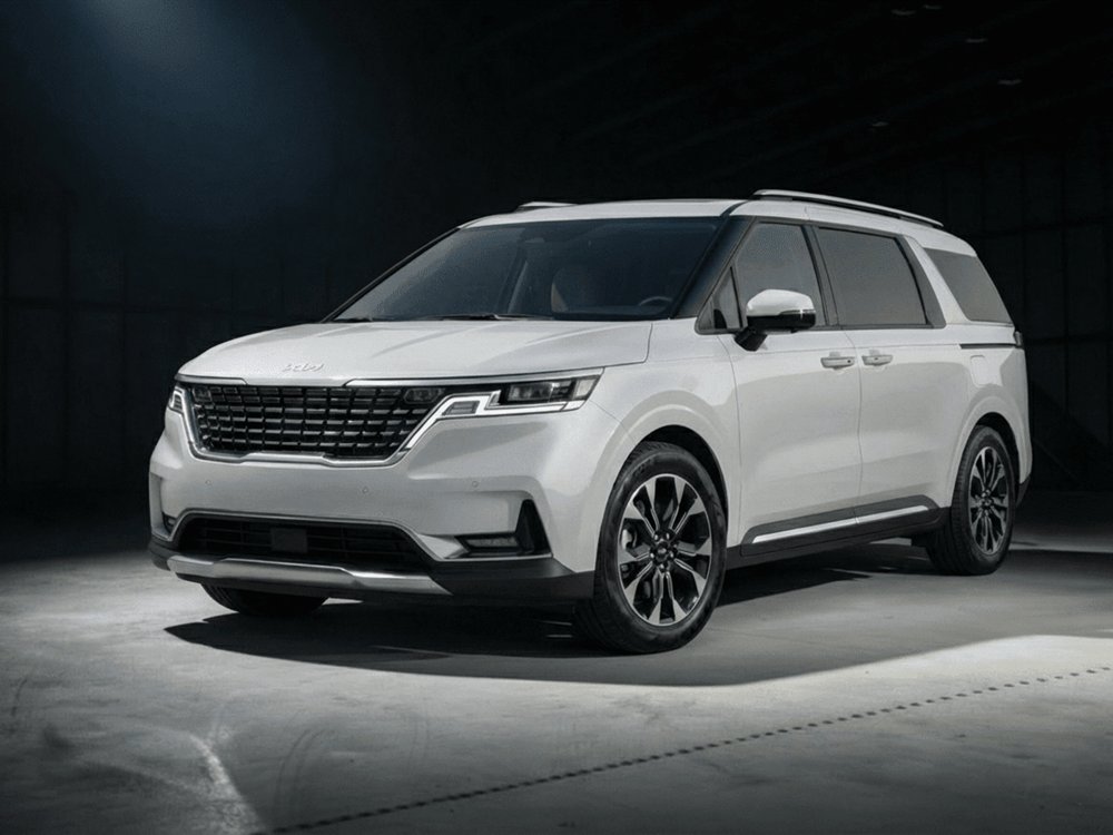 Минивэн Kia Carnival 2023 белого цвета, вид спереди сбоку